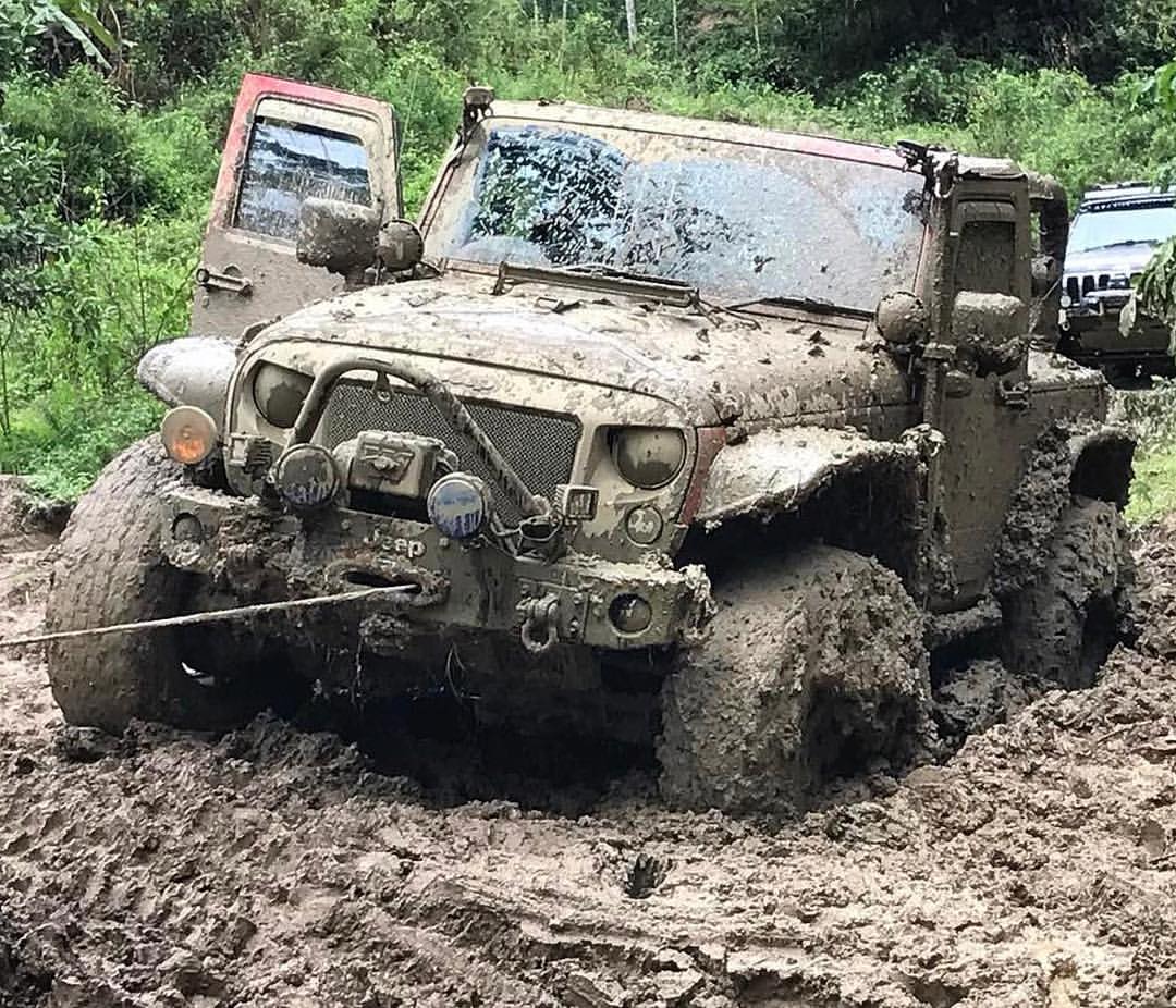 Ein Jeep zieht sich mit der Seilwinde aus dem Schlamm