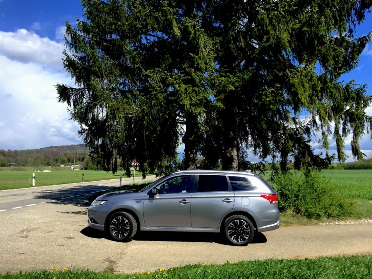 Mitsubishi Outlander PHEV auf Landstrasse vor Baum