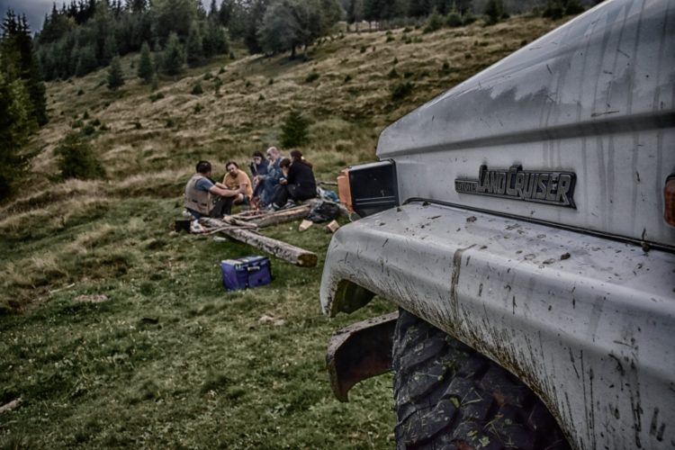 Offroad in den Ostkarpaten, Siebenbürgen, Rumänien: die Crew vor dem Toyota Landcruiser BJ70 am Lagerfeuer